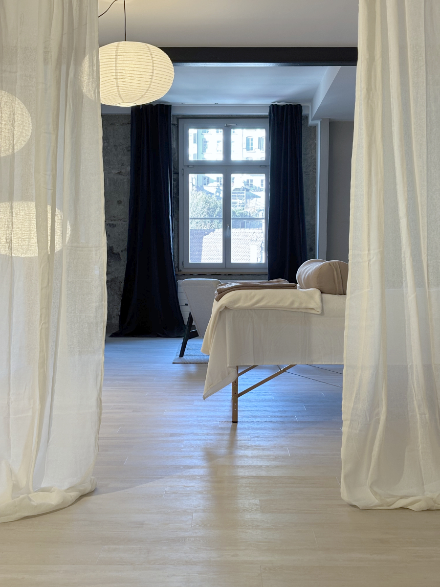 Interior Design mit weissen Leinenvorhängen, Therapie-Liege und dunkelgrauen Samtvorhängen