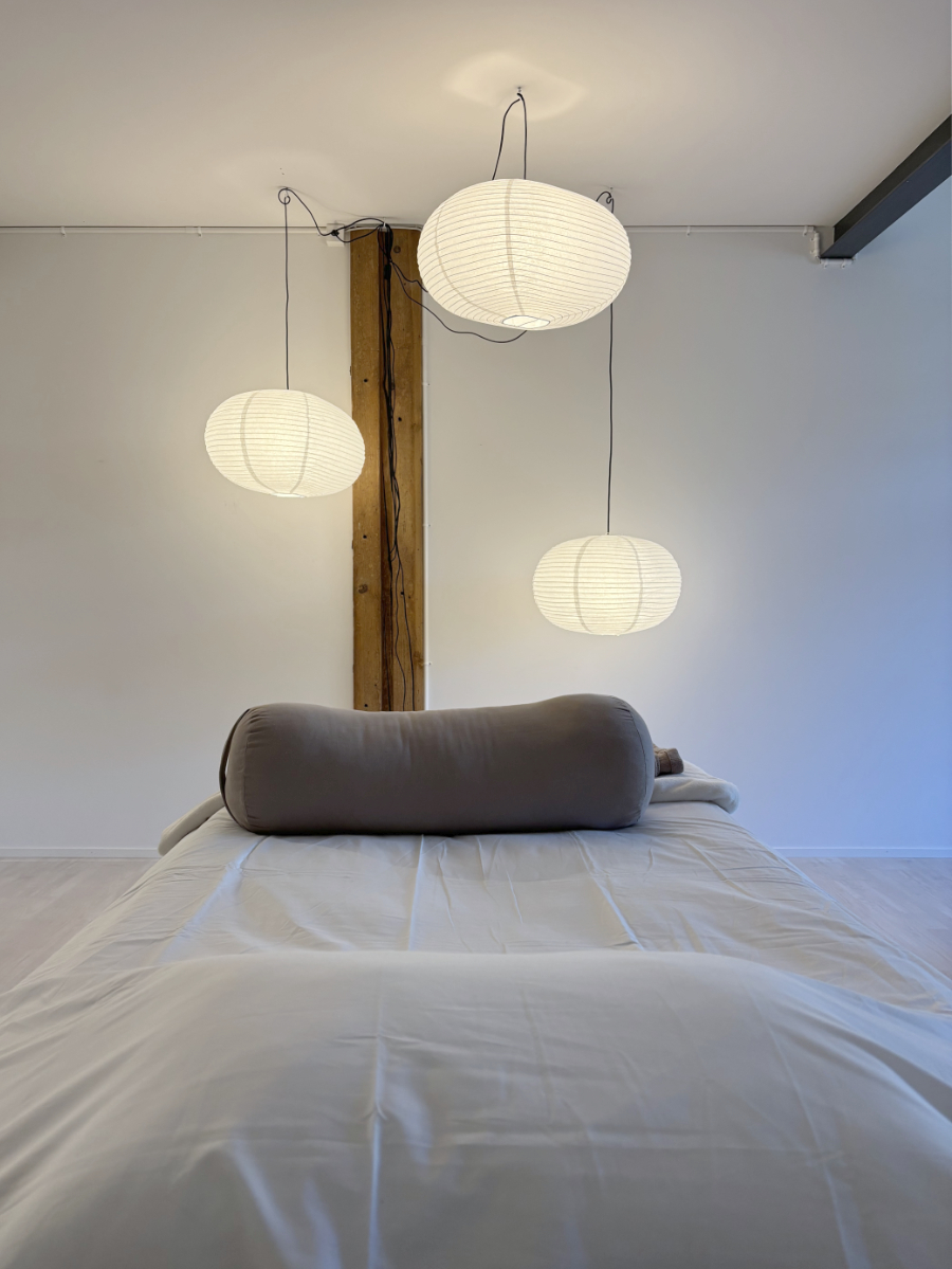 Interior Design mit Therapie-Liege, grossen Reispapierlampen und Holzbalken